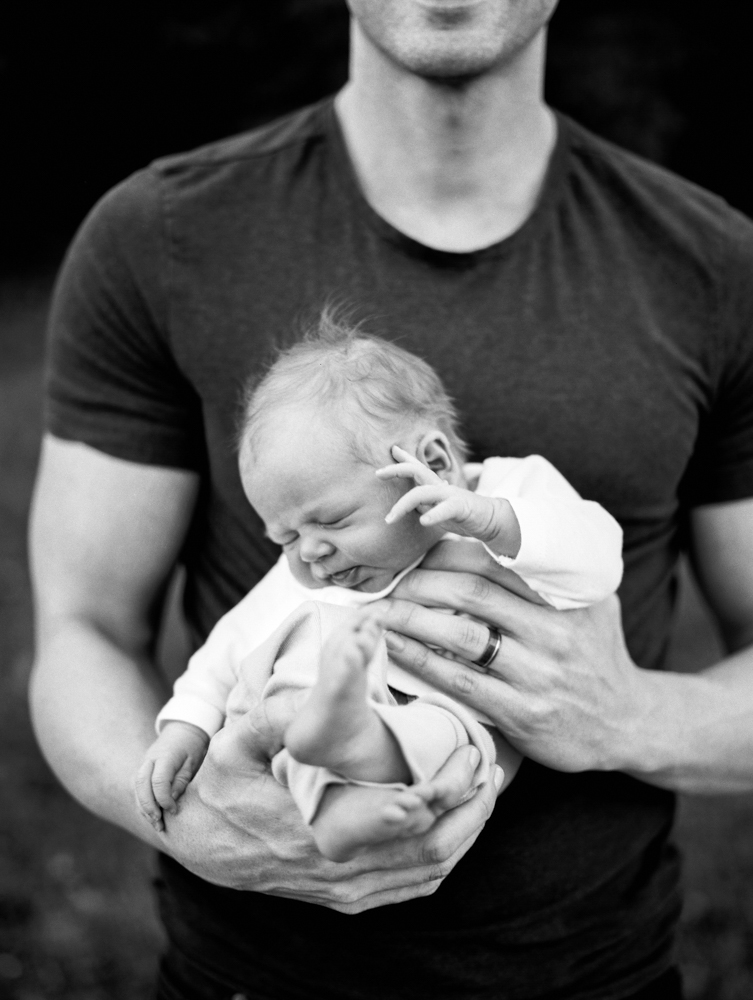 close up of baby in father's arms