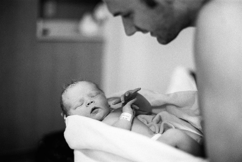 father looking at newborn son