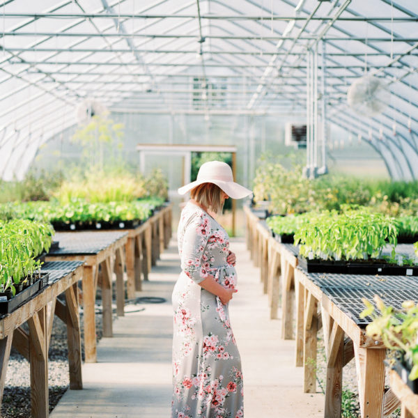 pregnant woman wearing hat in greenhouse amy rau photography