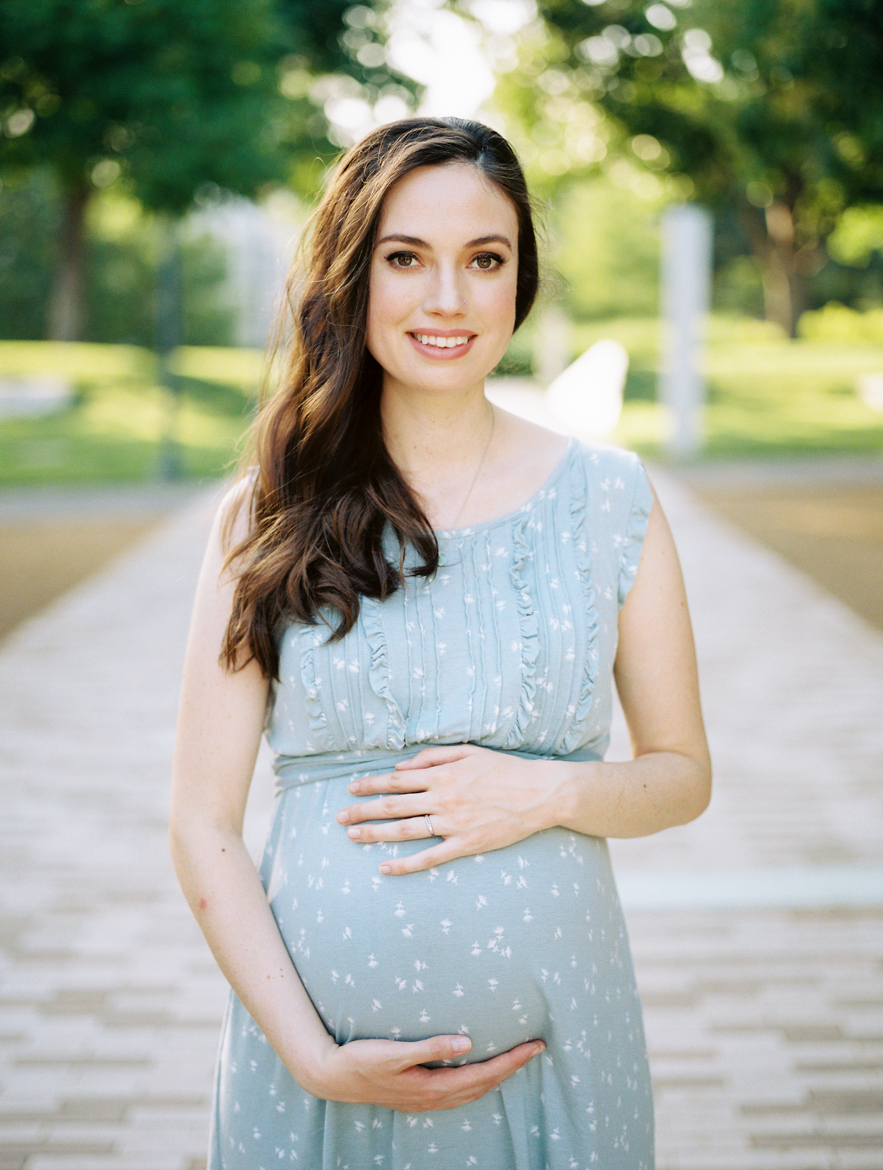 pregnant woman holding belly and smiling