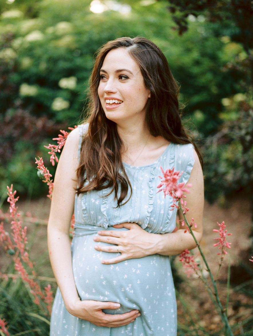 pregnant woman holding belly and laughing