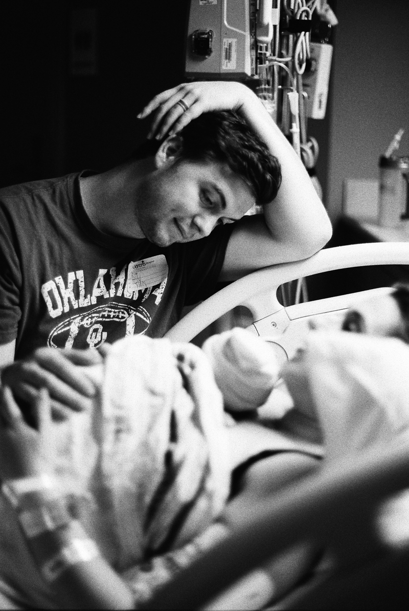 father looking down at newborn baby