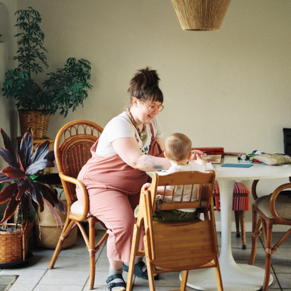 mother sitting at table with toddler in high chair