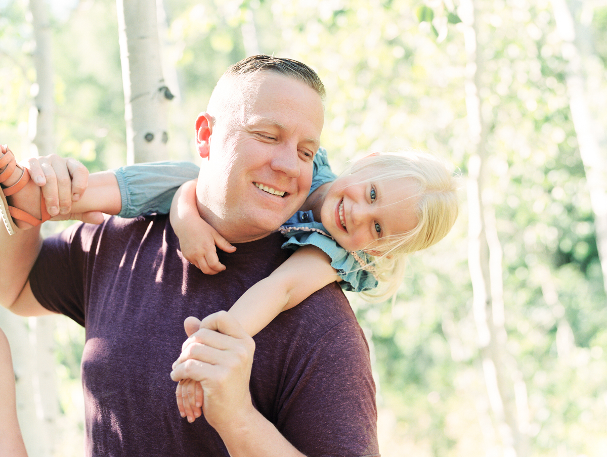 father giving child shoulder ride