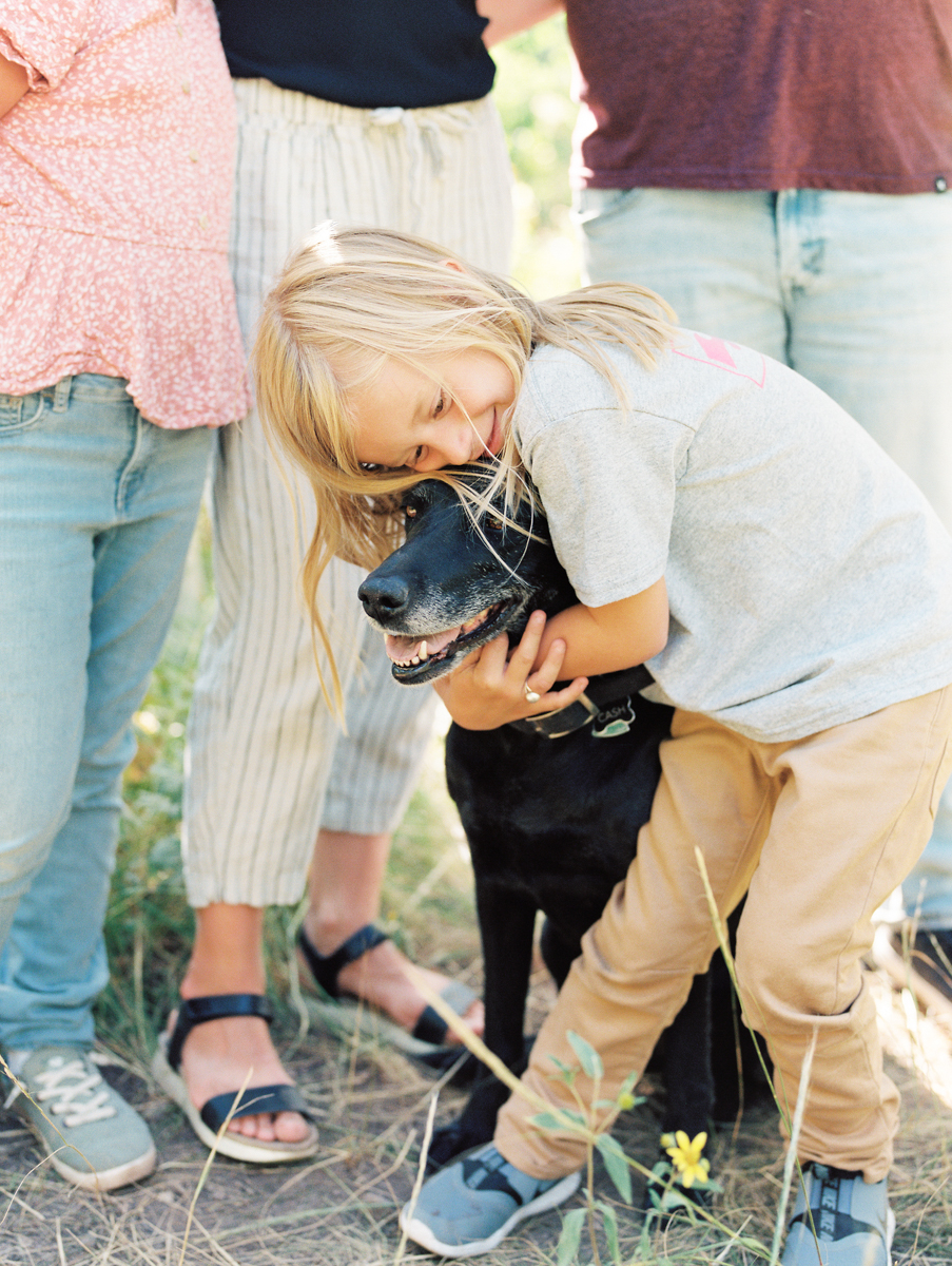 young boy hugging dog