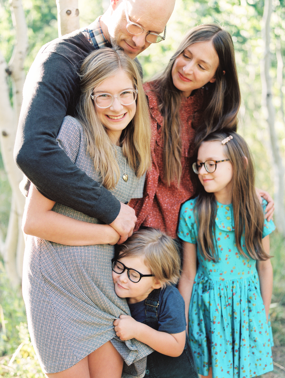 close up of daughter snuggled by family members