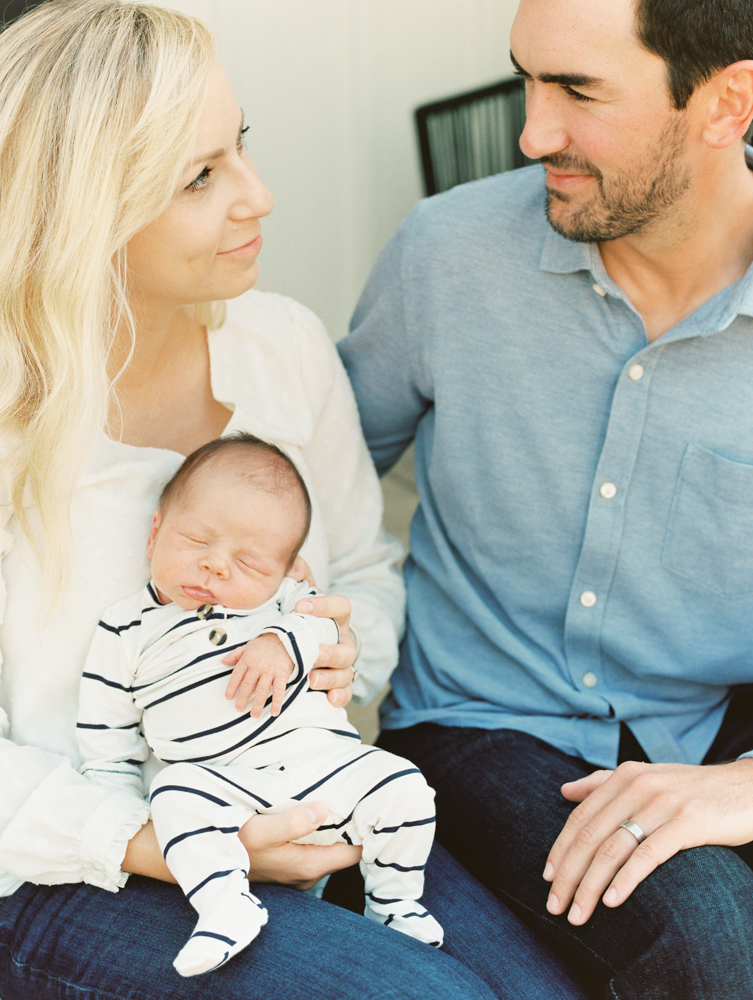 new parents looking at each other while holding baby