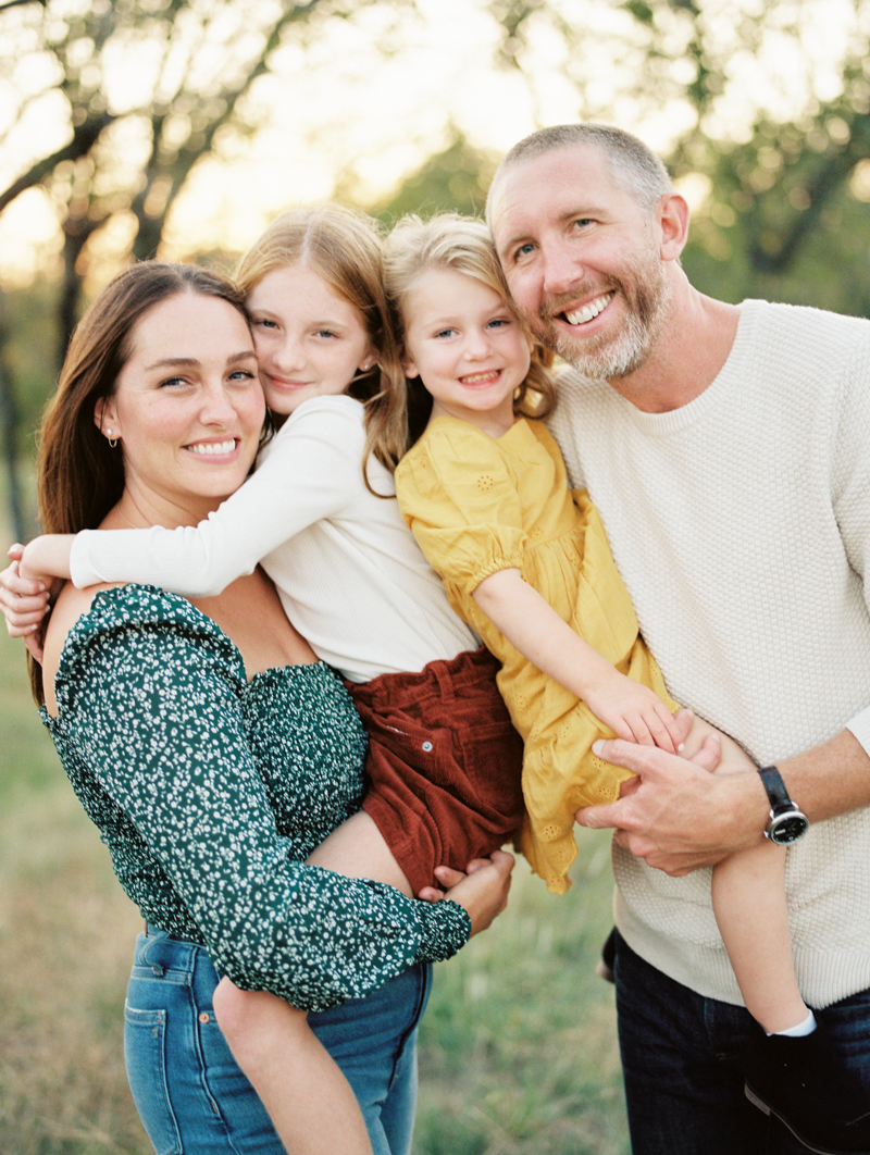 mother and father holding two young daughters