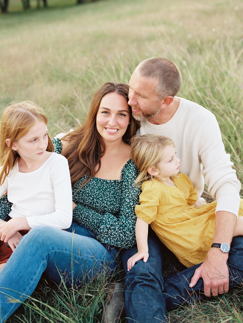 young family cuddled up on the ground