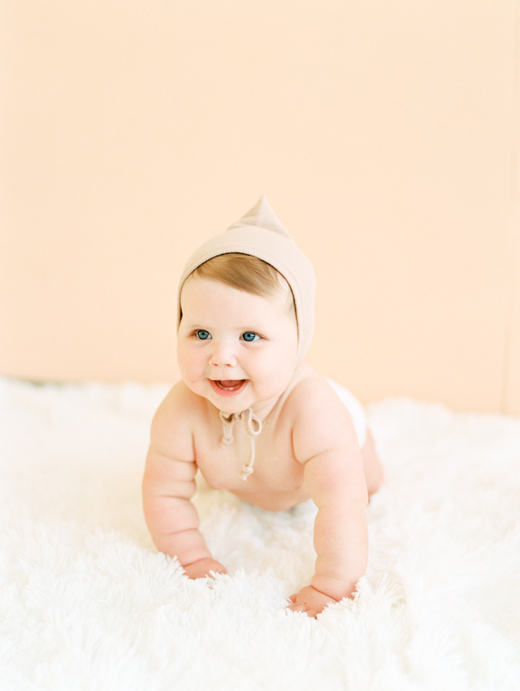 young baby in hat crawling