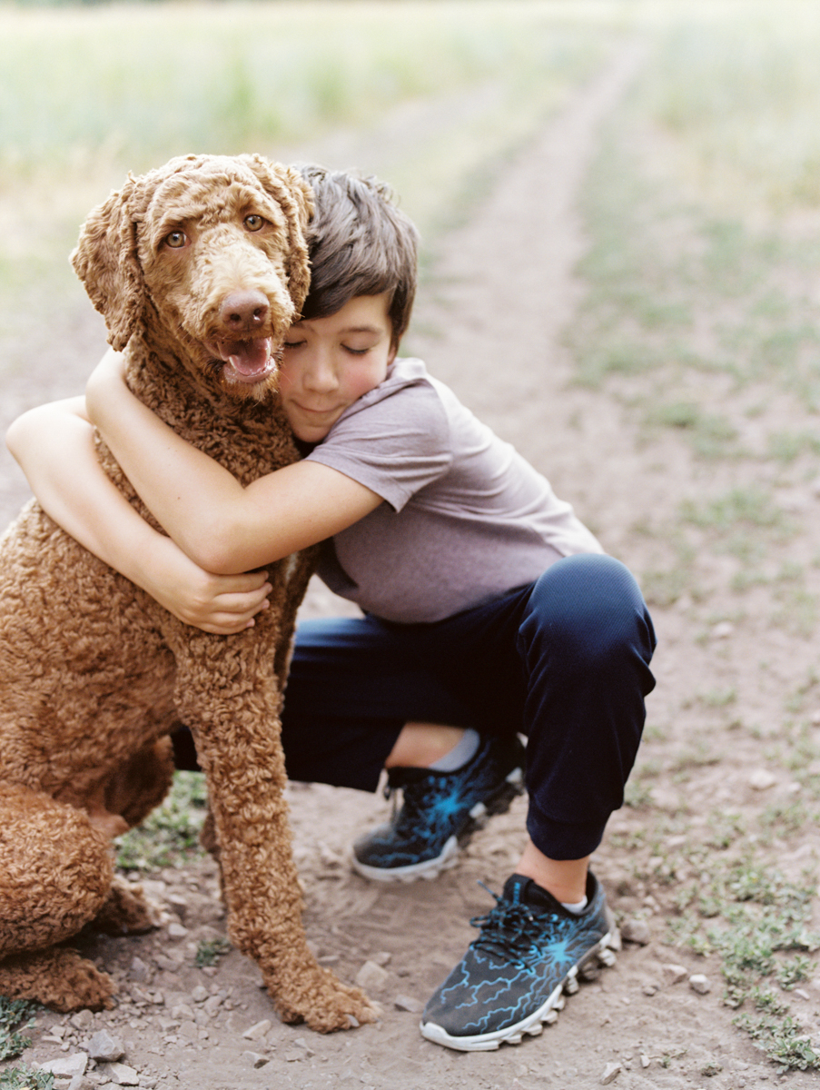 son hugging dog