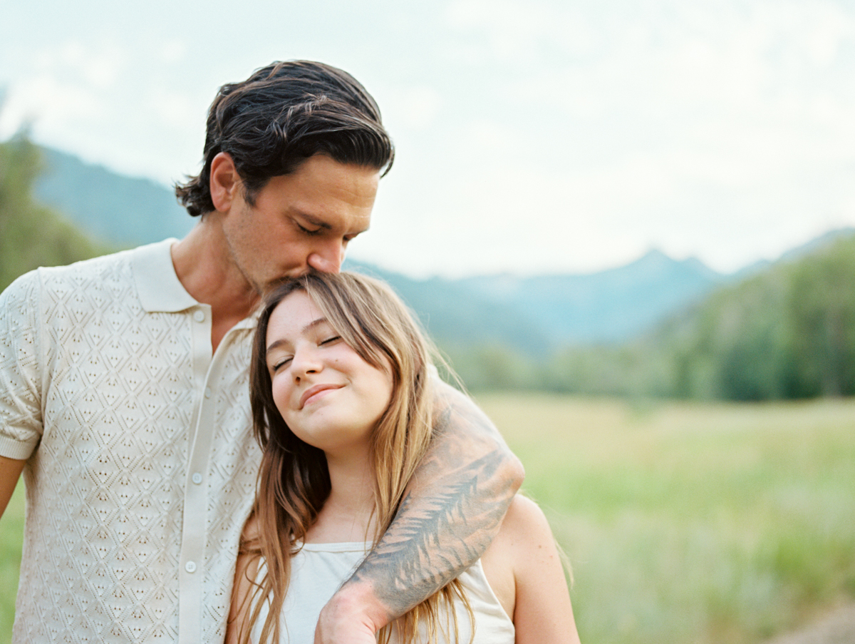 dad kissing daughter's head