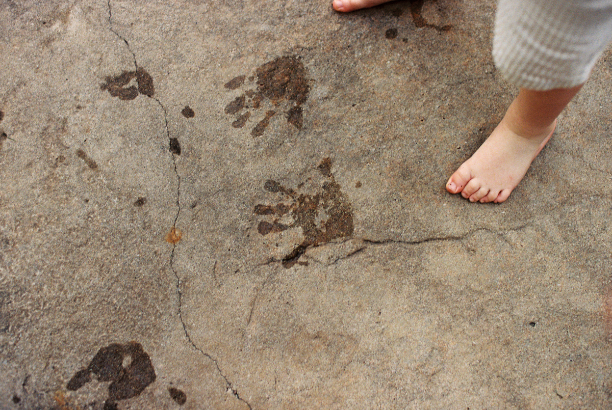 detail photo of little handprints on cement