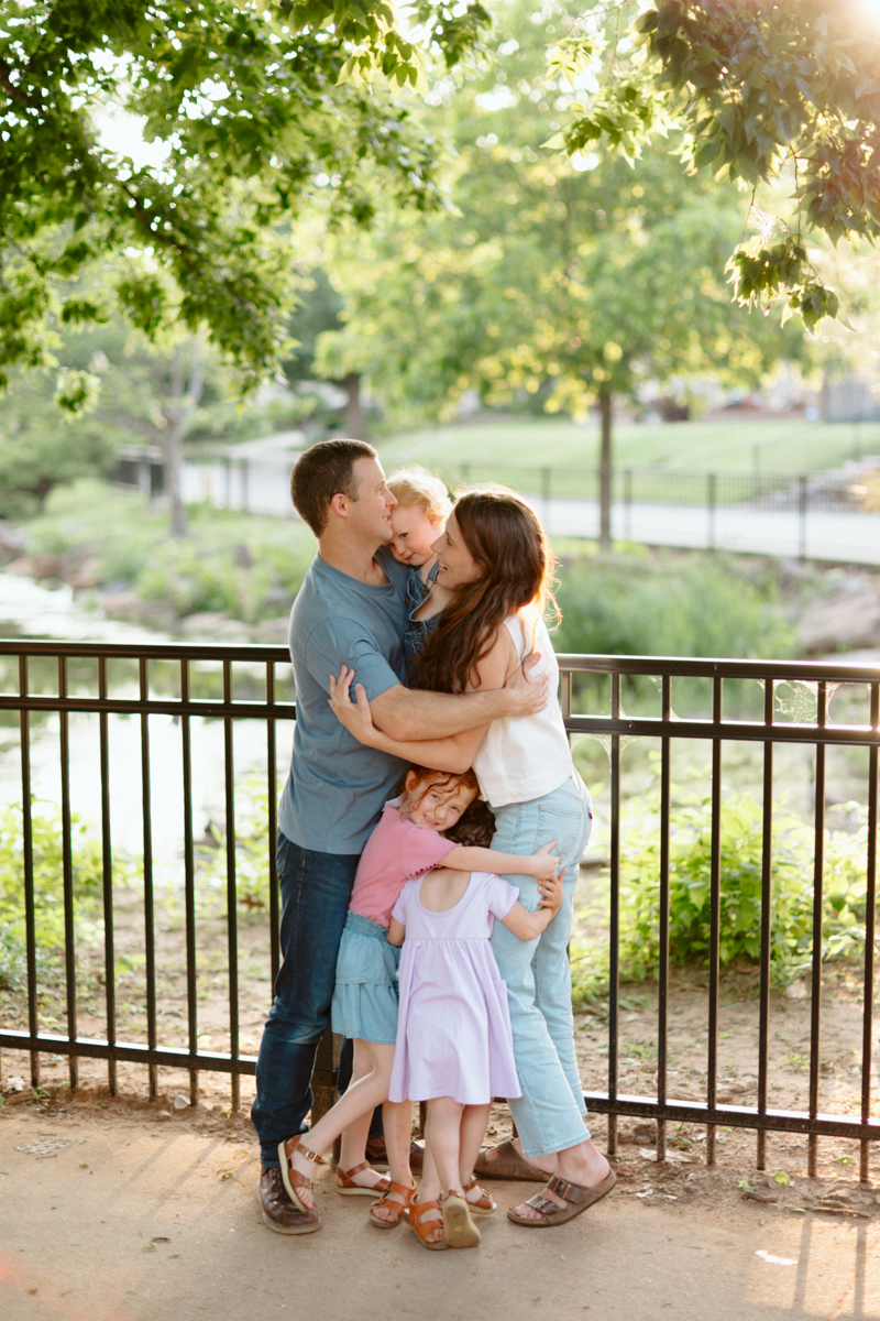 young family embracing during a summer family photo session in Oklahoma City