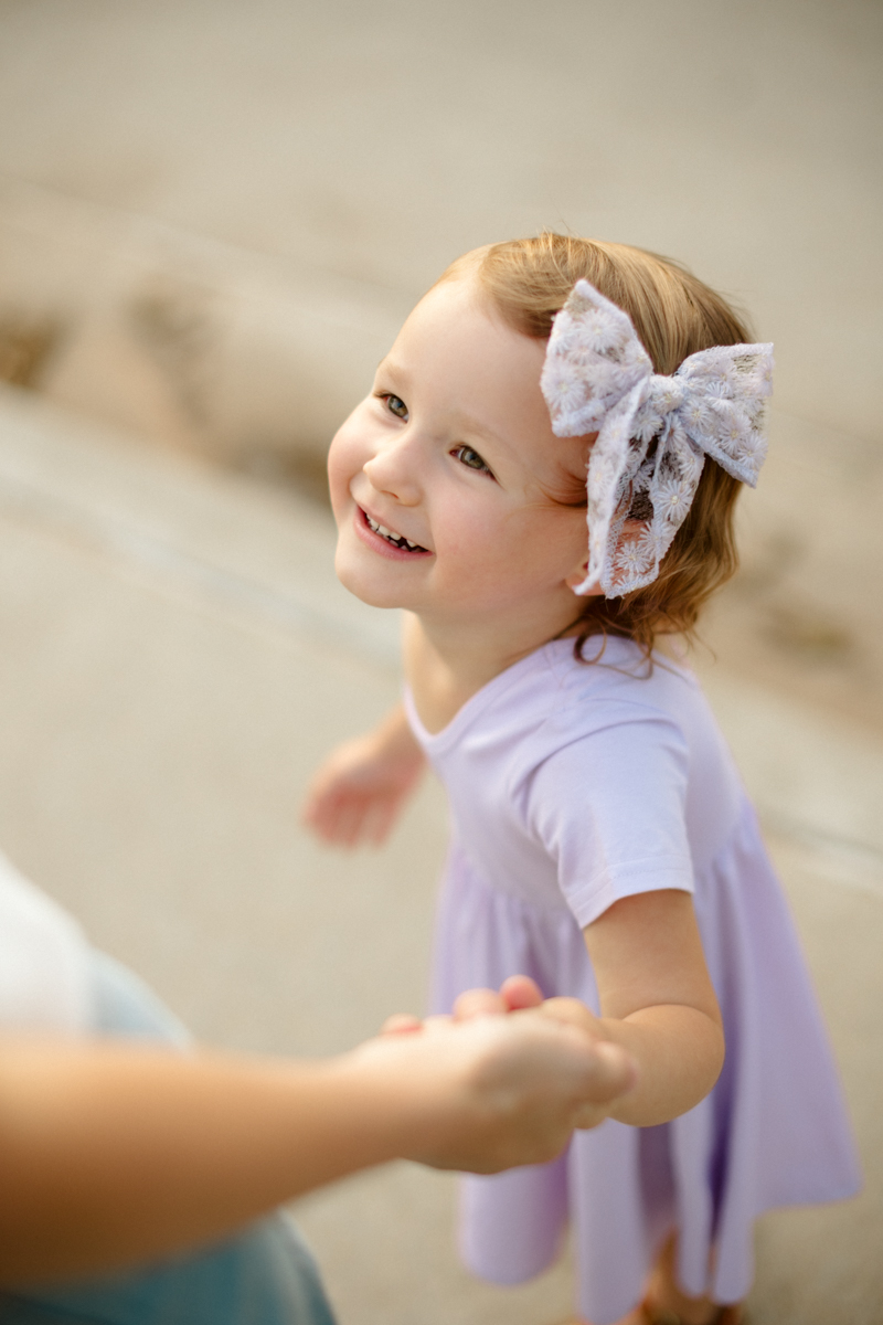 young girl looking up at her mother and smiling during a lifestyle family photo session in Oklahoma City