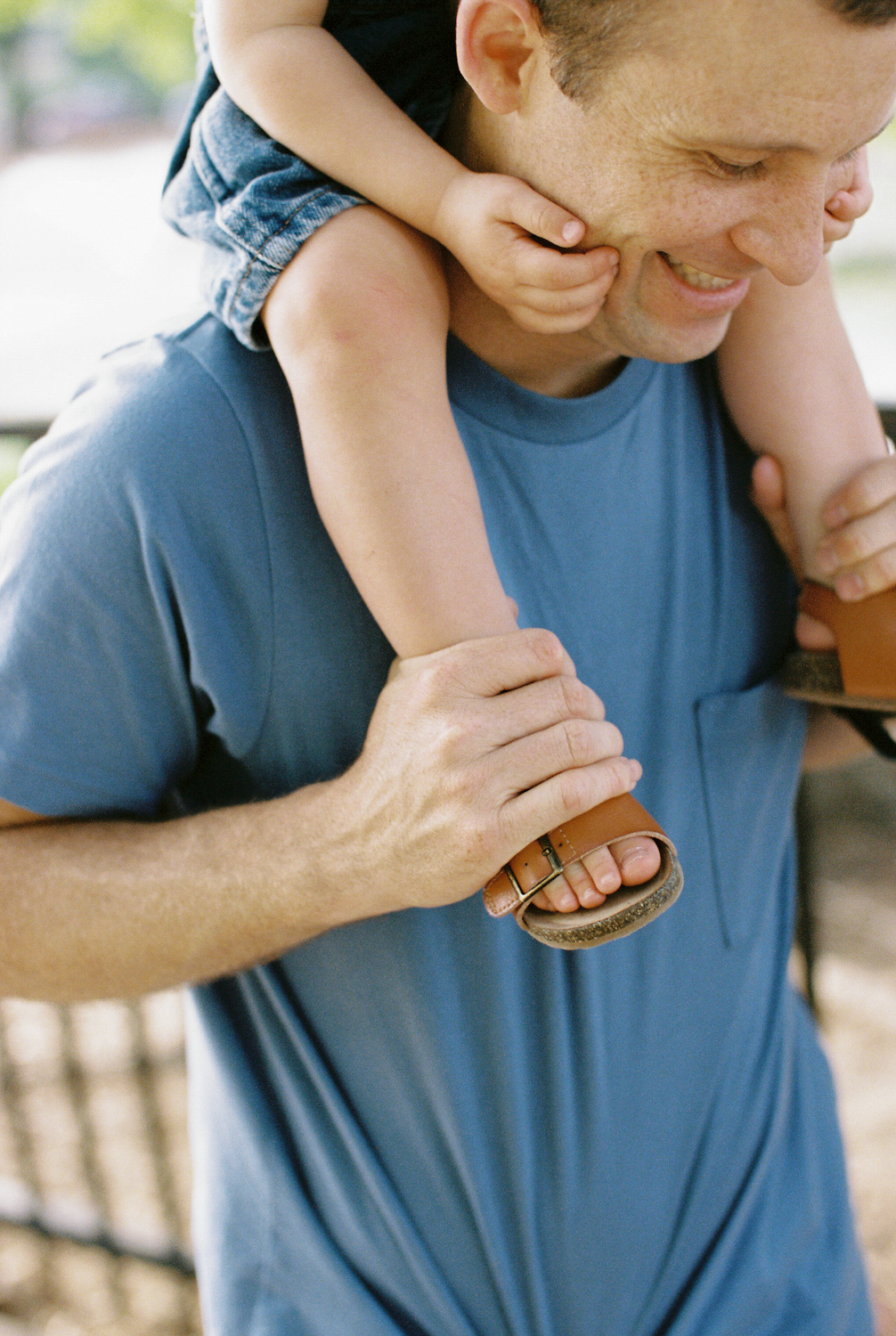 dad holding his young son on his shoulders during a family session in oklahoma city