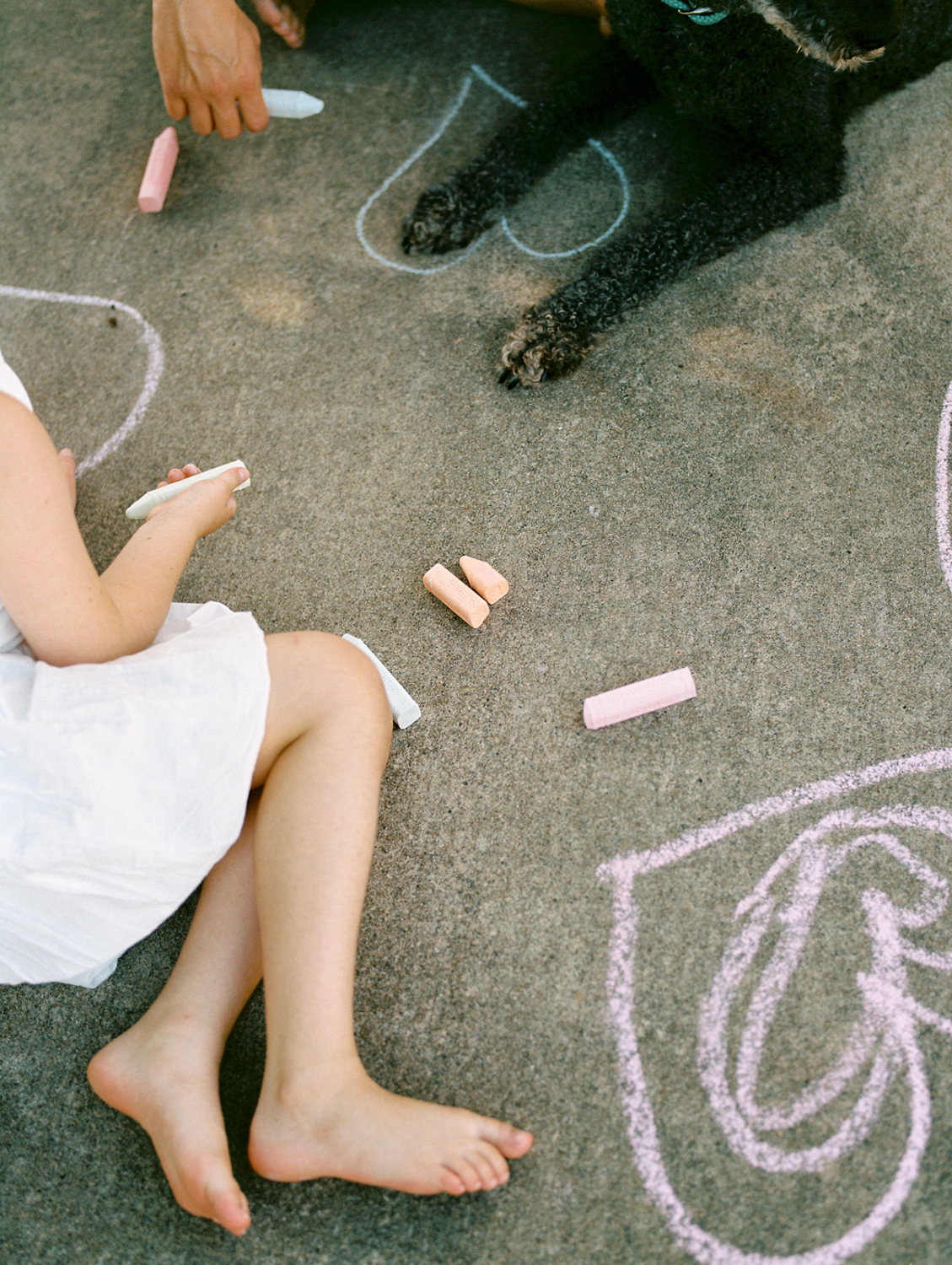 close up of child playing with chalk and chalk drawings at their oklahoma city home
