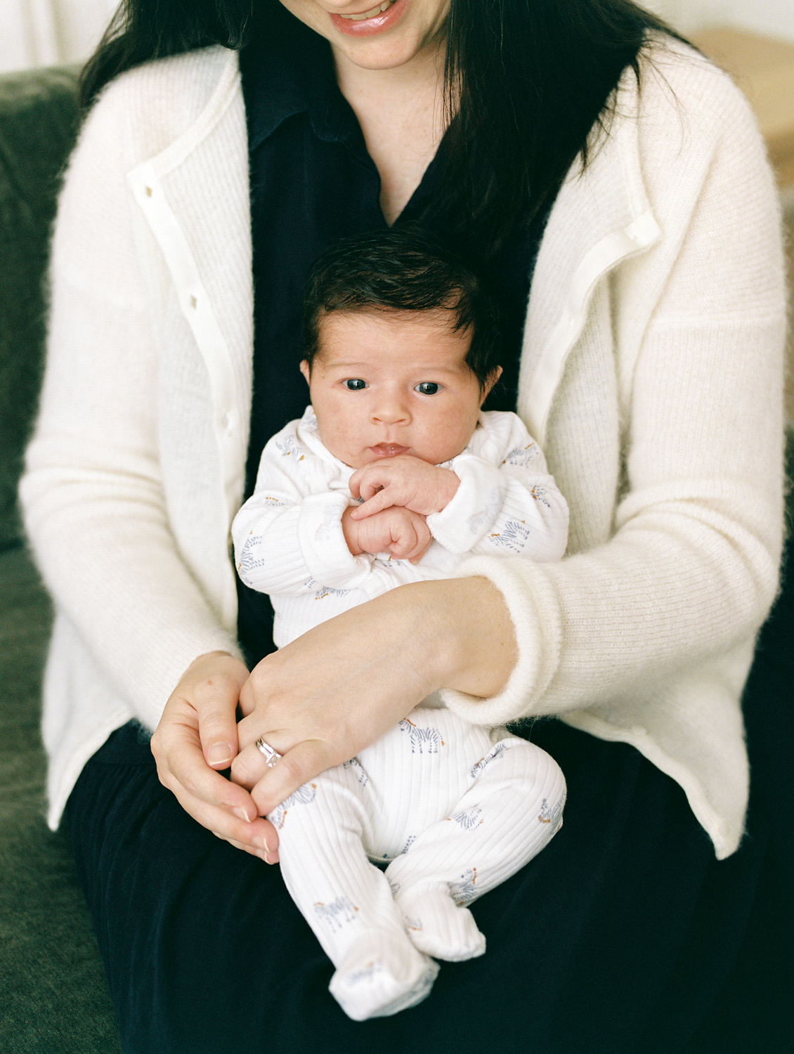 film portrait of a newborn baby boy sitting in mom's lap