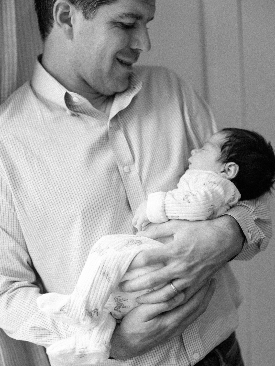 black and white photo of dad holding baby boy