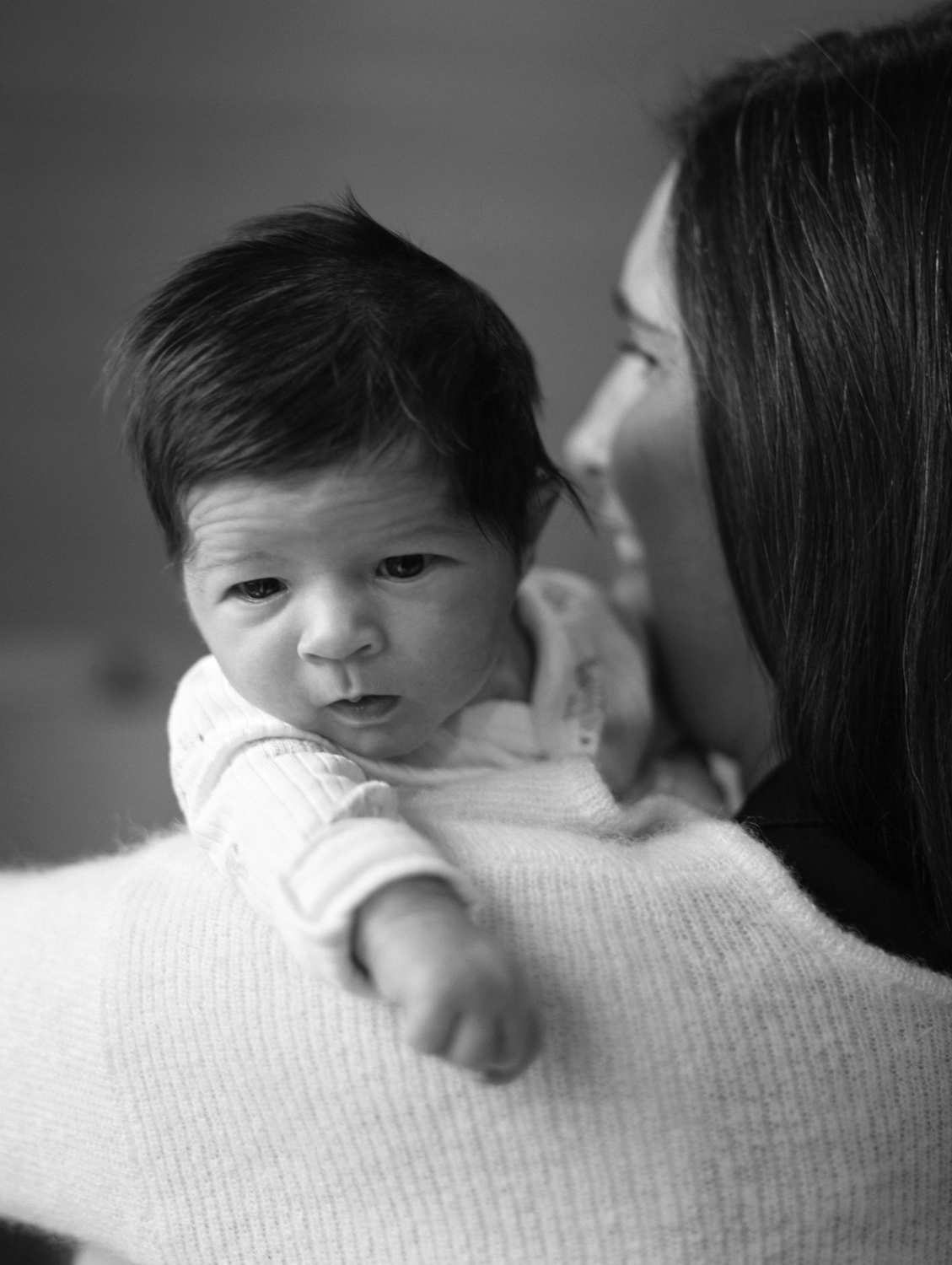 black and white photo of newborn peeking over mom's shoulder in an oklahoma city newborn session