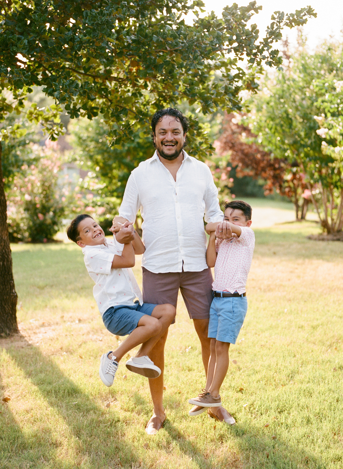 dad lifting young sons