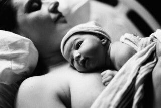 newborn baby laying on mother's chest